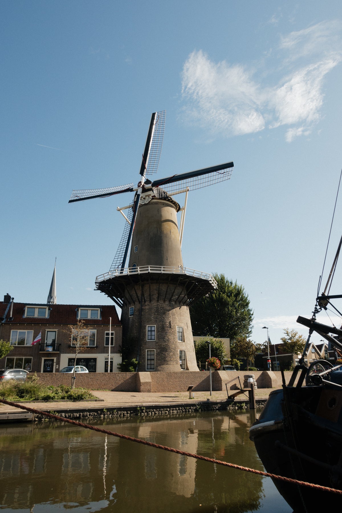 A traditional Dutch windmill rising above a canal and brick houses in the Netherlands