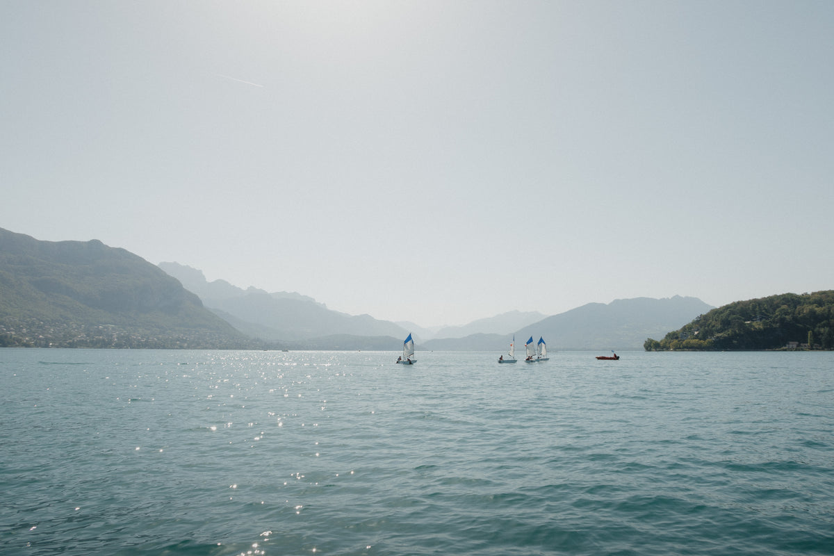 Sailboats on Lake Annecy in France, framed by the mountains of the French Alps