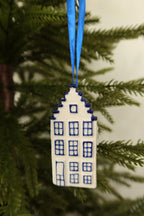 Front view of the Delft blue canal house ornament showing its hand-painted windows, door and stepped gable