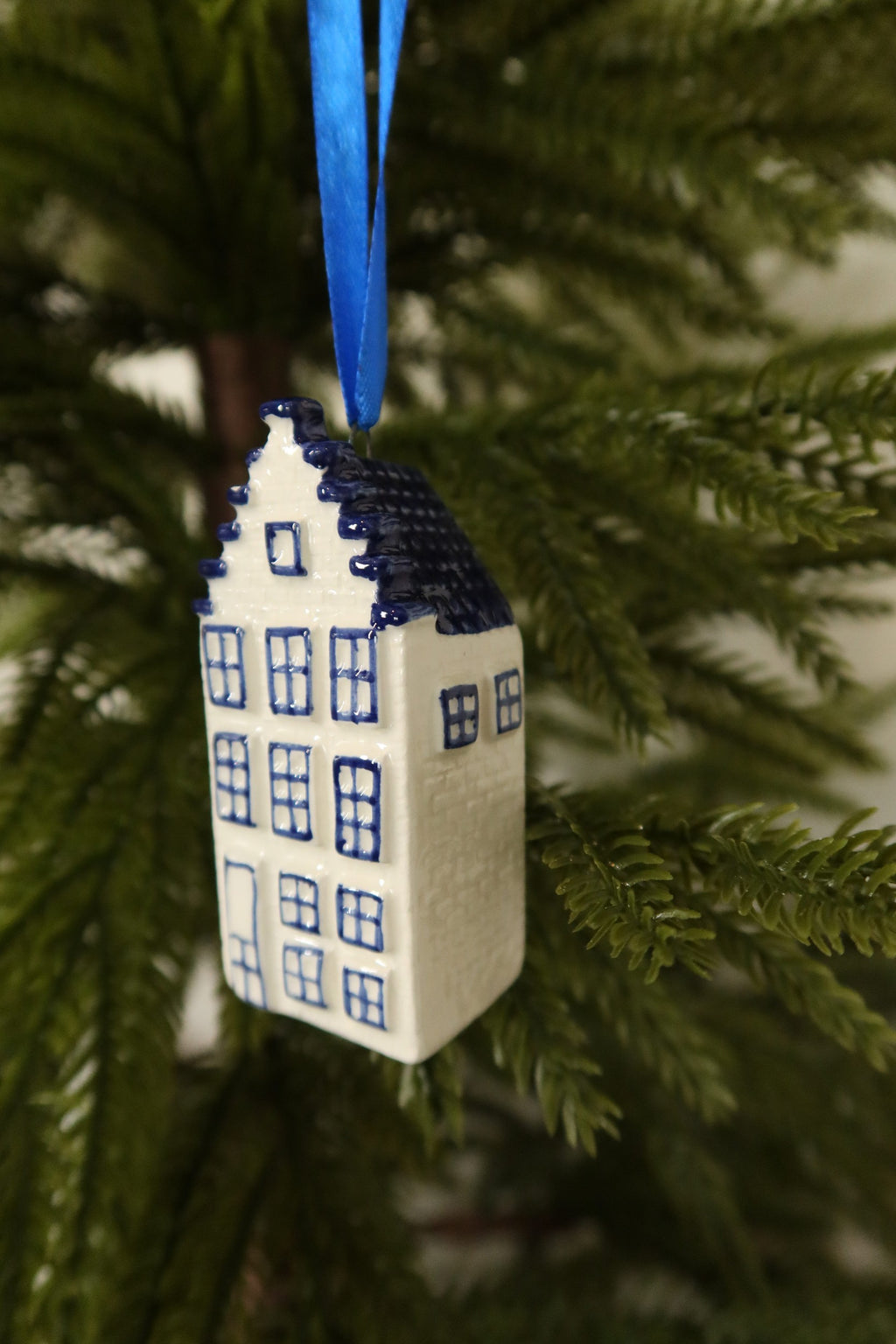Side view of the Delft blue canal house ornament showing its blue tiled roof and side windows