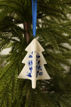 Front view of the three-dimensional Delft blue tree ornament showing its crossed panels and floral motifs