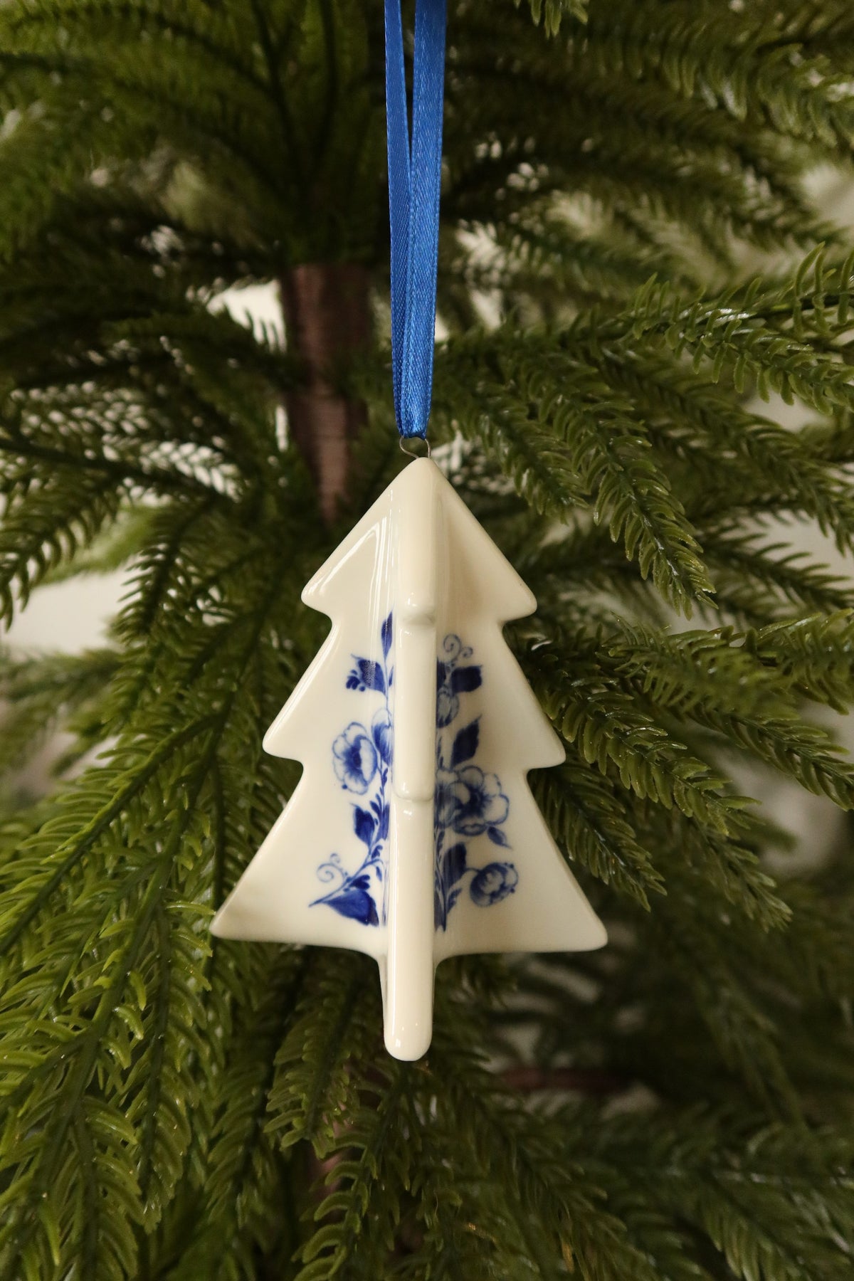 Front view of the three-dimensional Delft blue tree ornament showing its crossed panels and floral motifs