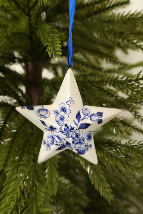 Closer view of the Delft blue floral star ornament showing its painted blue flowers and leaves