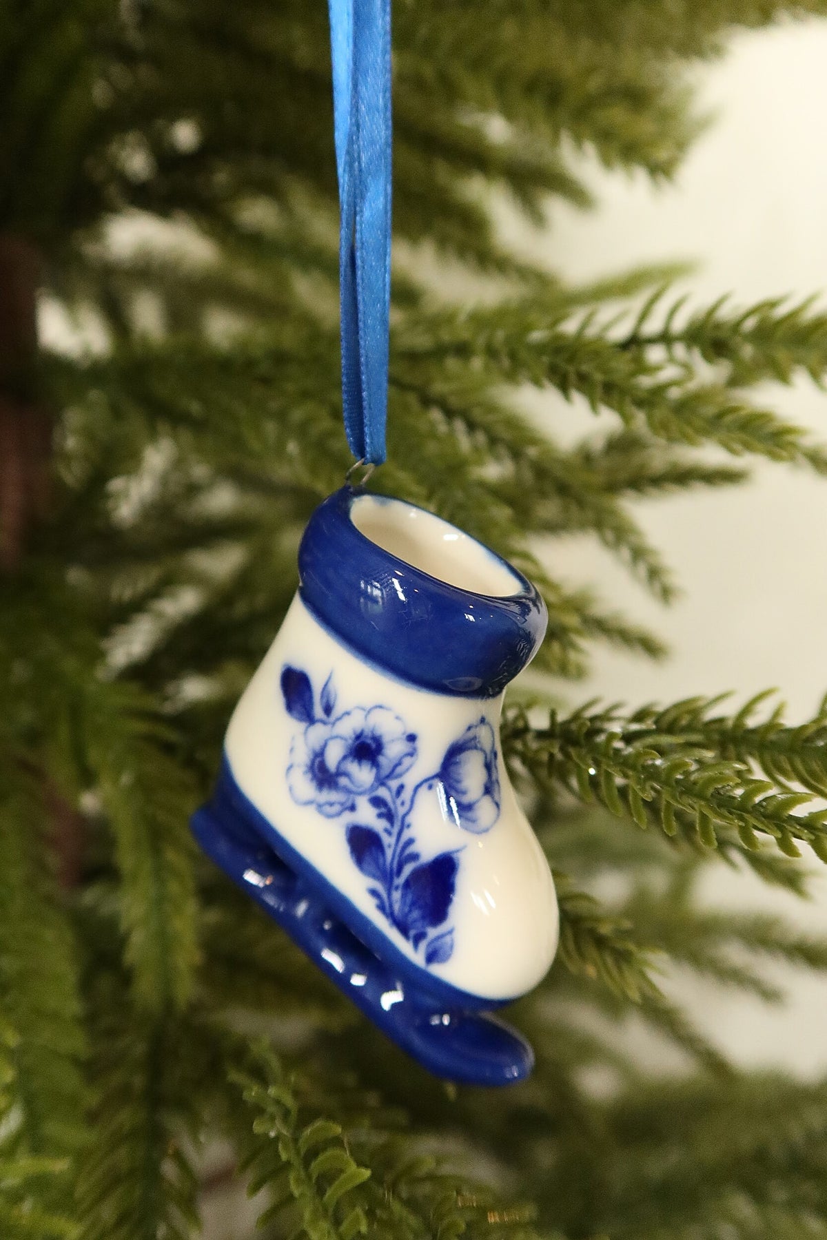 Closer view of the Delft blue ice skate ornament showing its blue rose motif, glazed cuff and blue blade