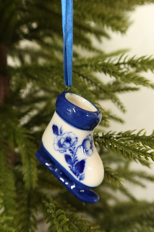 Closer view of the Delft blue ice skate ornament showing its blue rose motif, glazed cuff and blue blade