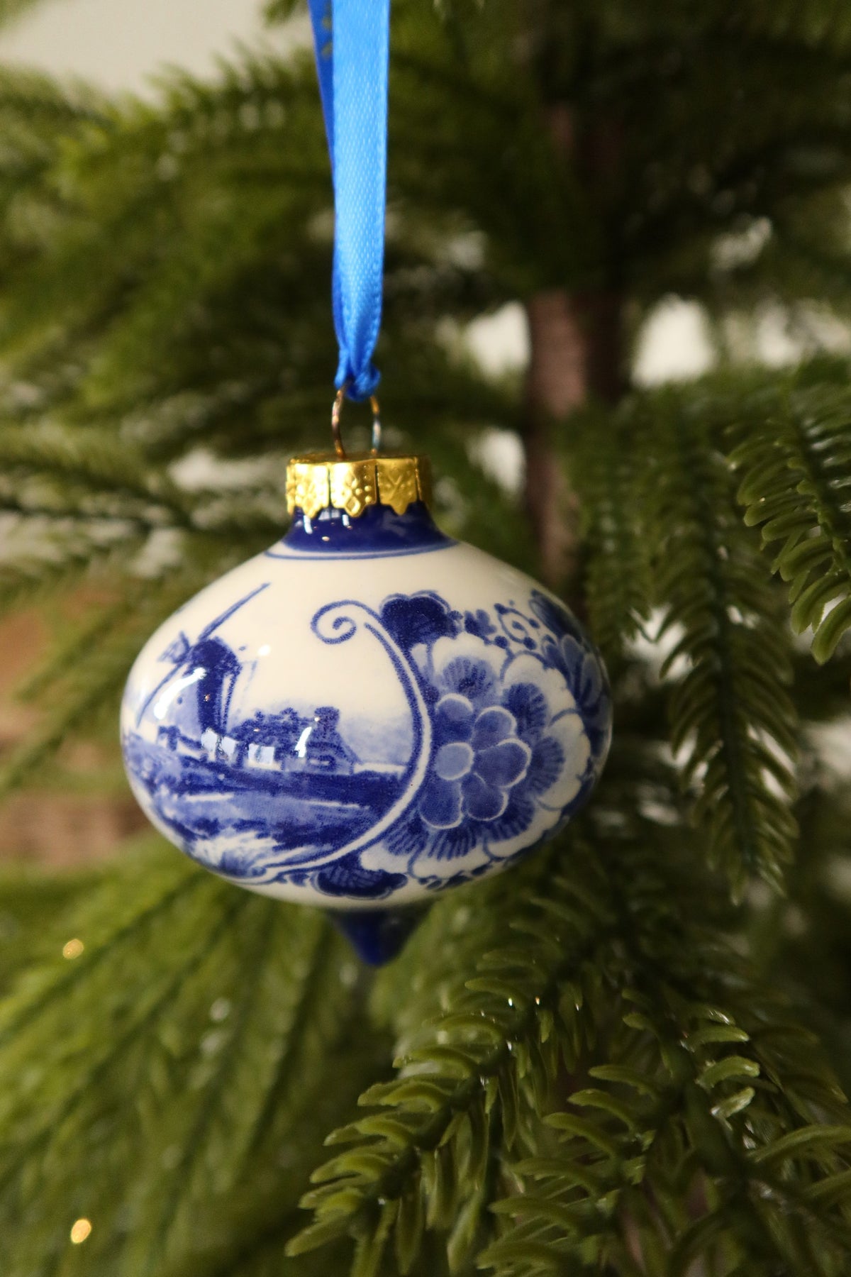 Side view of the Delft blue drop ornament showing the hand-painted floral border beside the windmill landscape