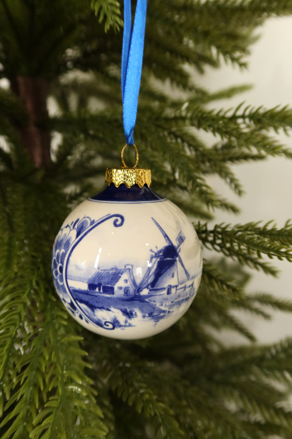 Closer view of the Delft blue bauble showing its painted windmill and farmhouse scene