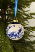 Closer view of the Delft blue bauble showing its painted windmill and farmhouse scene