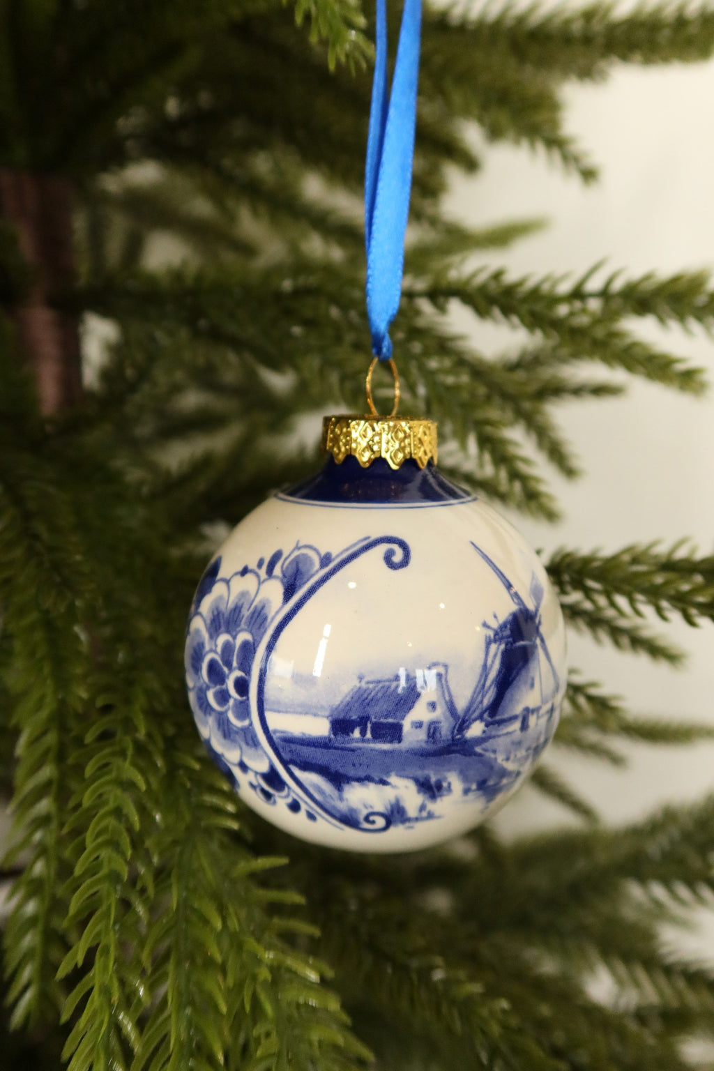 Side view of the Delft blue windmill bauble showing the scrolled floral border framing the landscape