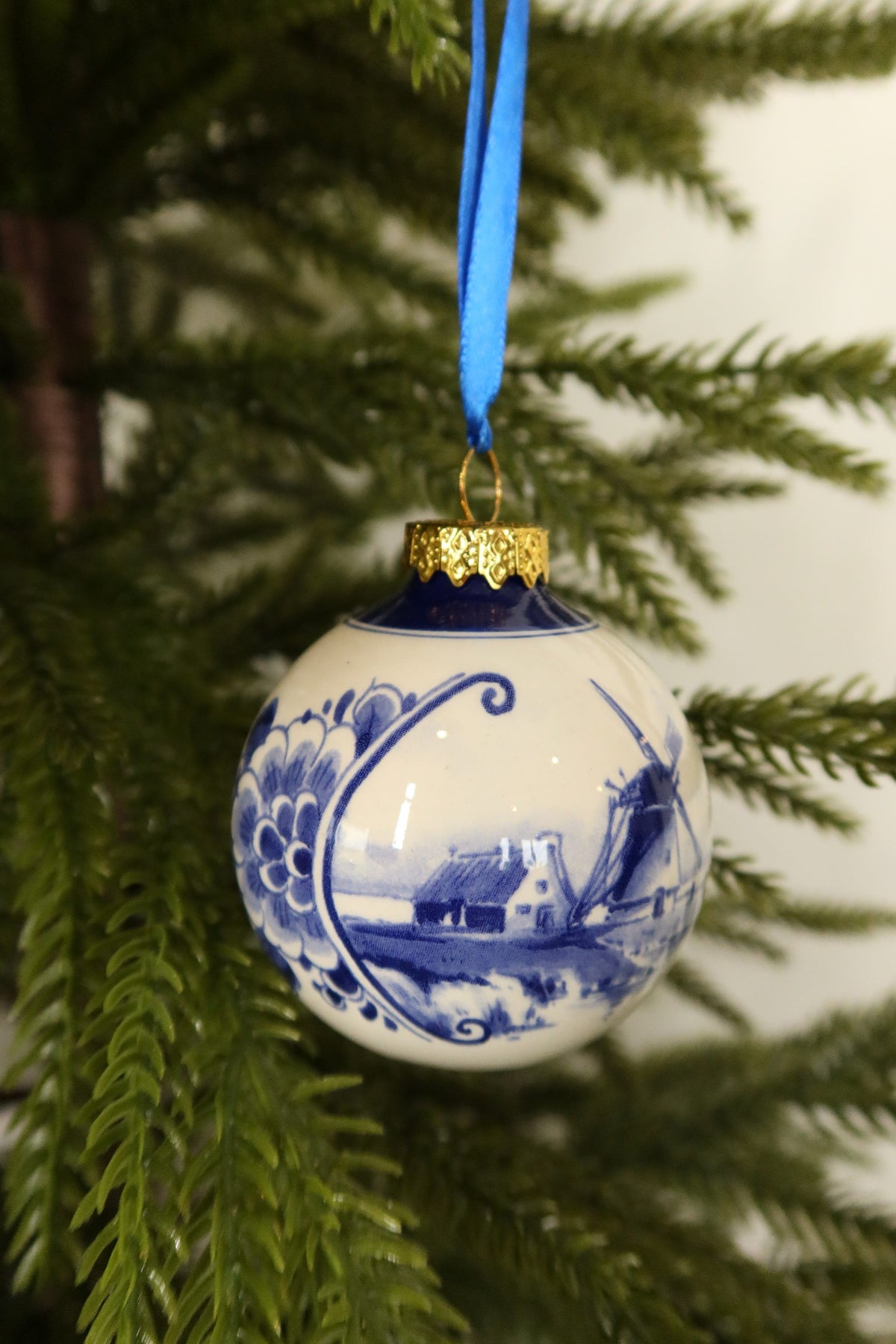 Side view of the Delft blue windmill bauble showing the scrolled floral border framing the landscape