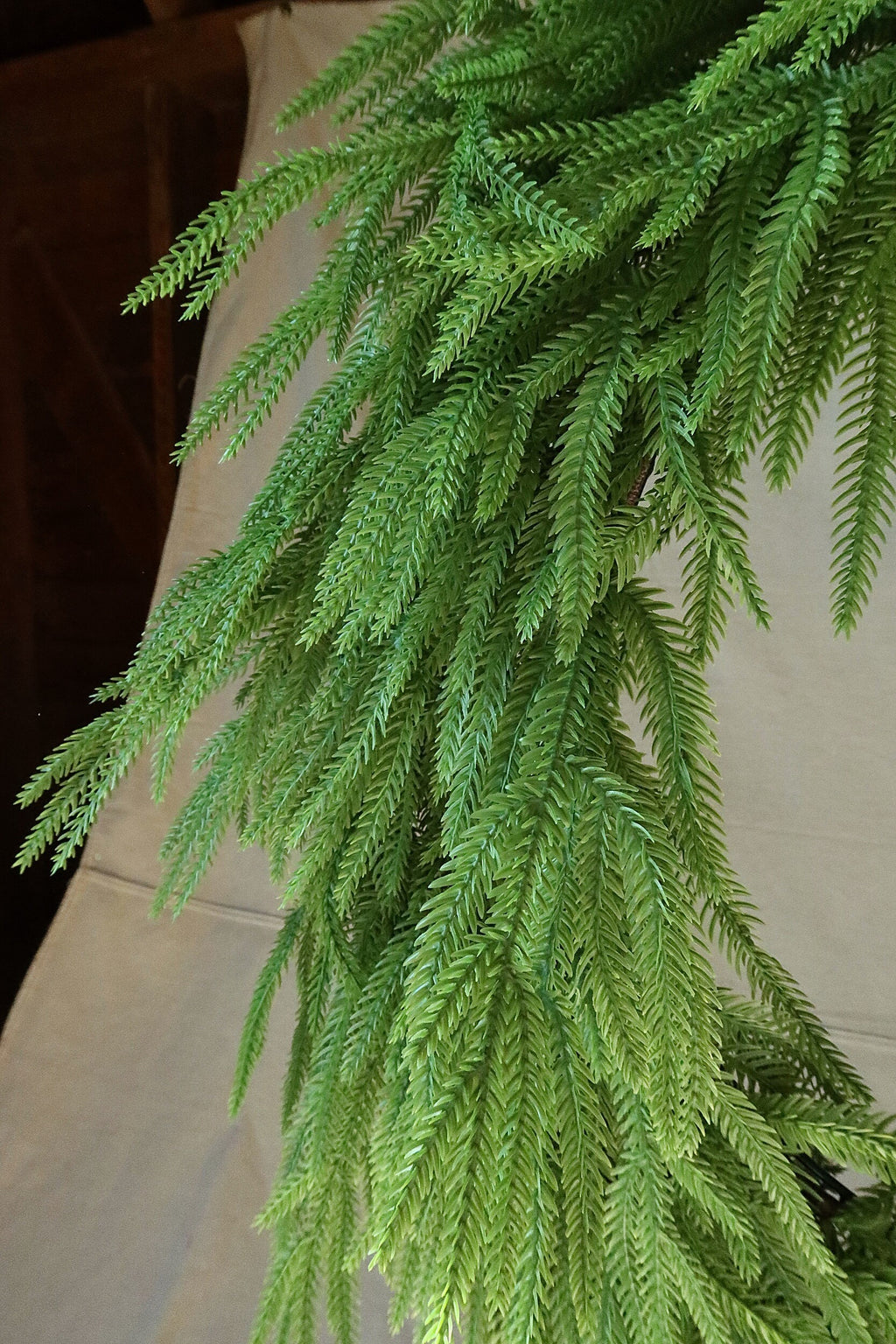 Close-up of the long, drooping faux Norfolk pine branches on the 36 inch wreath