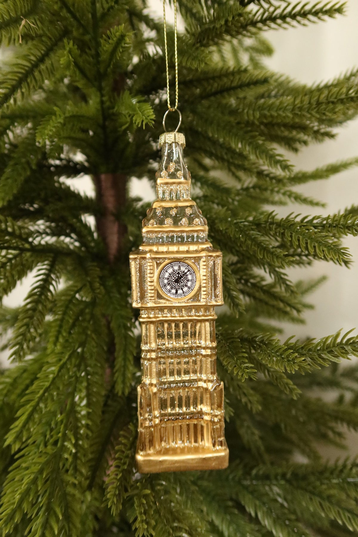 Closer view of the glass Big Ben ornament showing its painted clock face and gold tower details