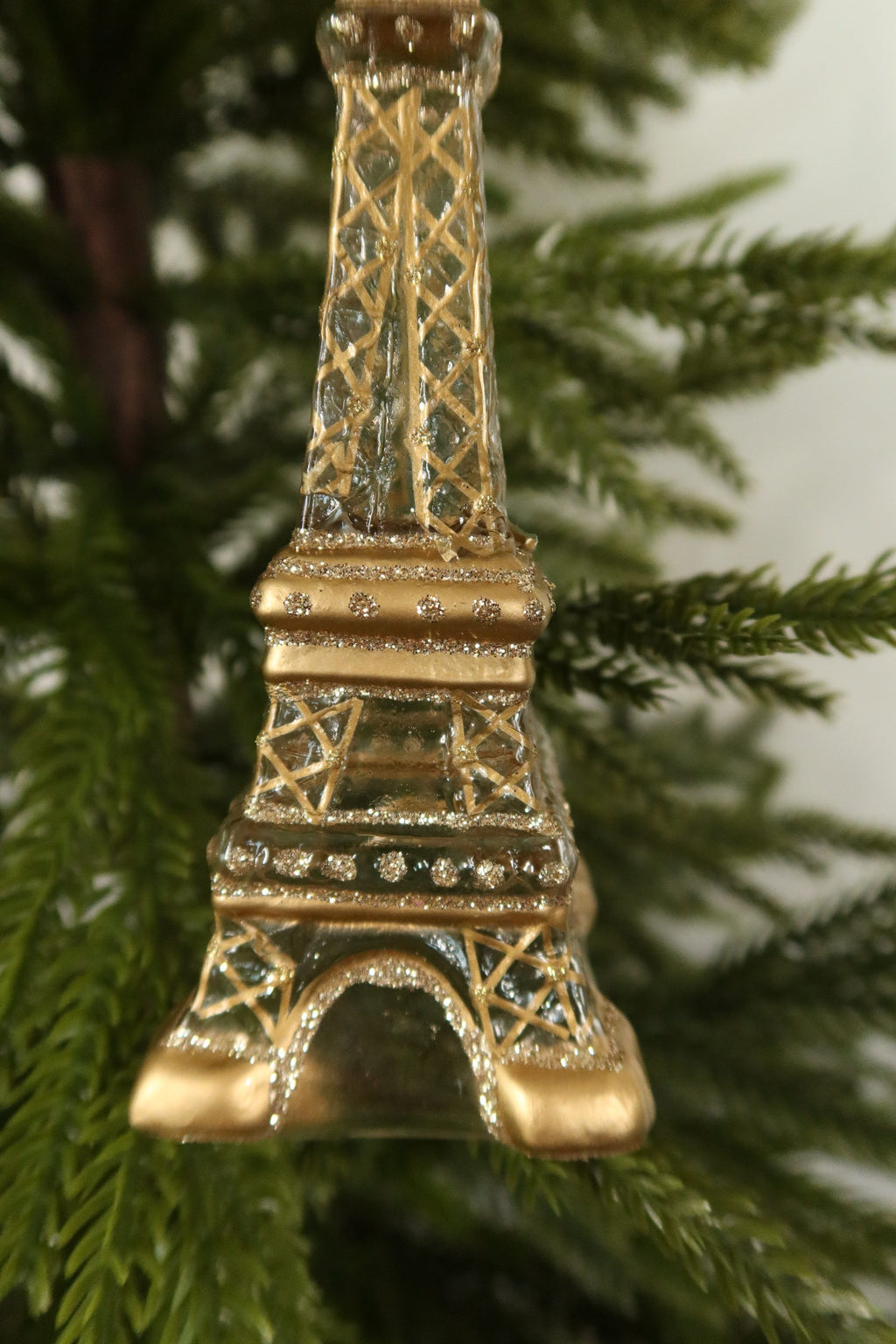 Close-up of the gold painted lattice, glitter bands and gold platform on the glass Eiffel Tower ornament