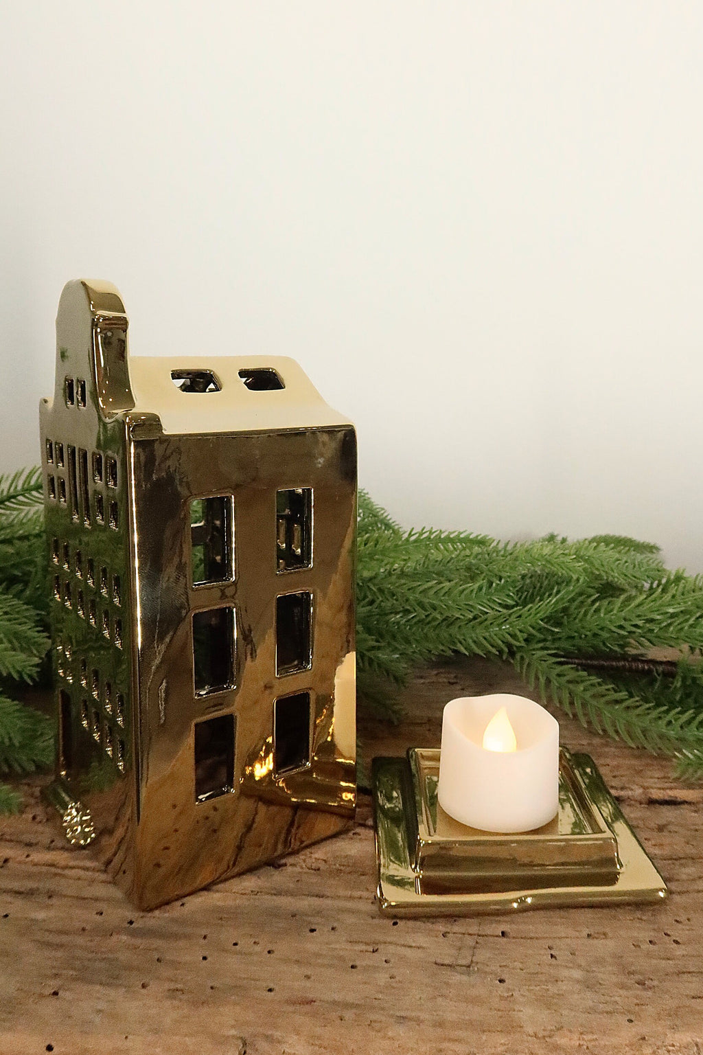 Bell-gable gold canal house tealight holder lifted off its base to show where the tealight sits