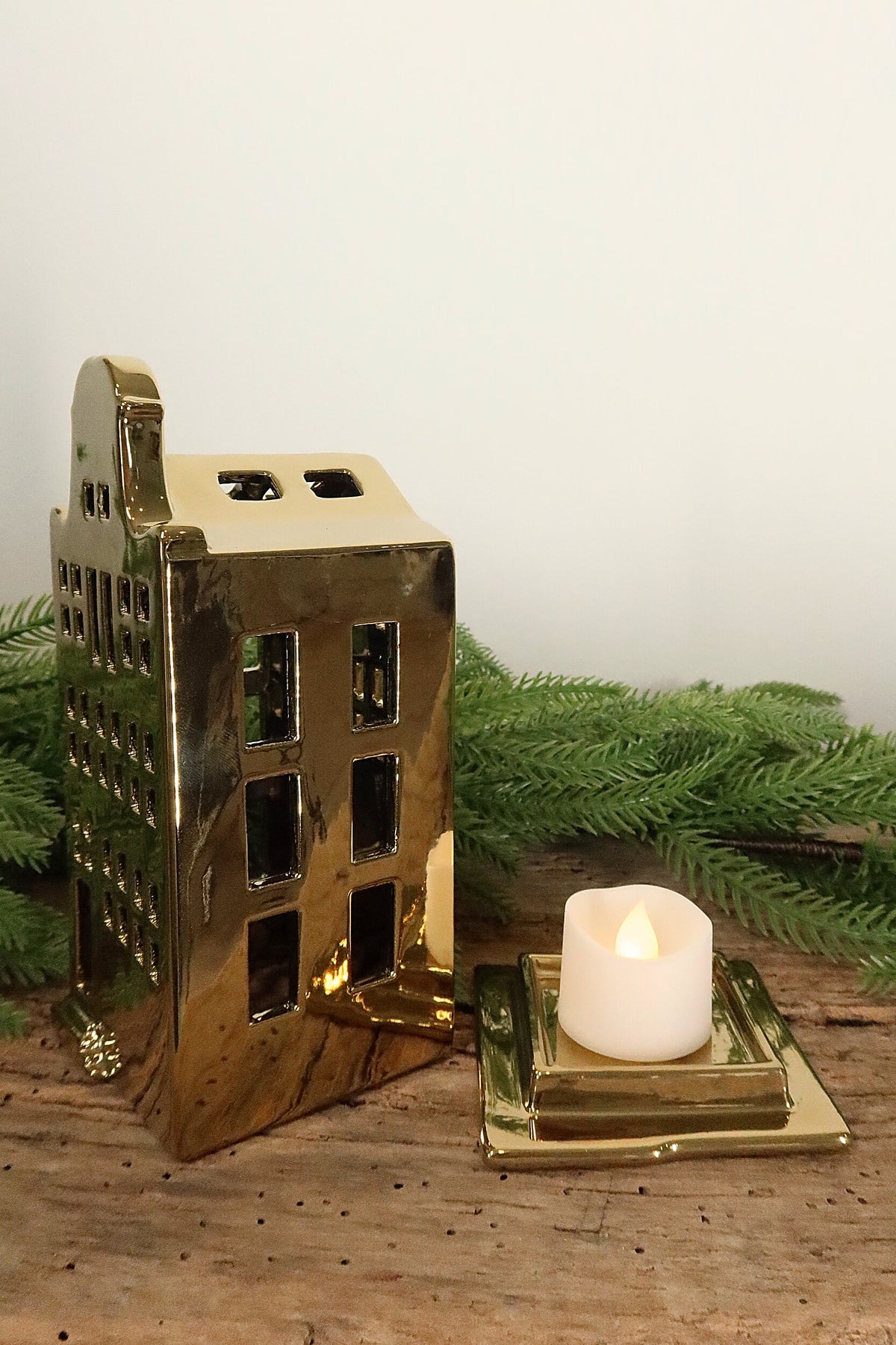 Bell-gable gold canal house tealight holder lifted off its base to show where the tealight sits
