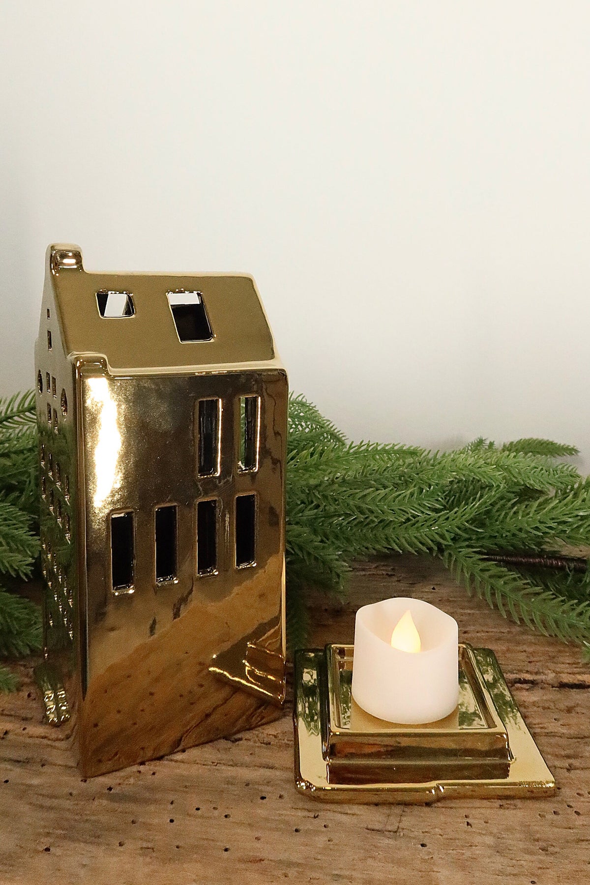 Spout-gable gold canal house tealight holder lifted off its base to show where the tealight sits