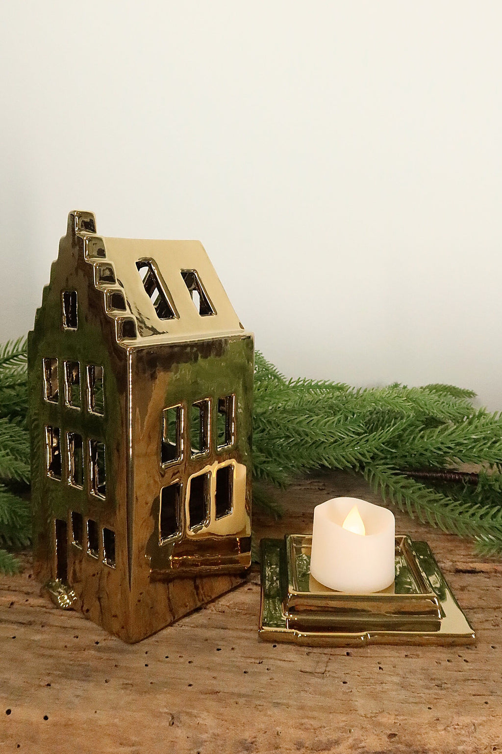 Stepped-gable gold canal house tealight holder lifted off its base to show where the tealight sits
