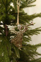 Gold metal trumpeting angel Christmas ornament with textured wings and gown hanging by jute twine on an evergreen tree