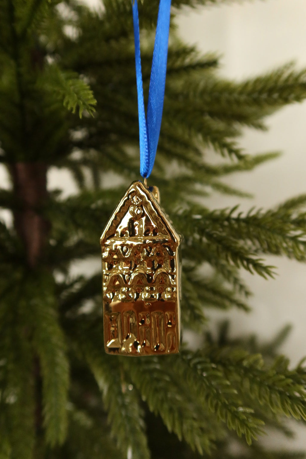 Closer view of the pointed gable gold mini canal house ornament showing its arched windows