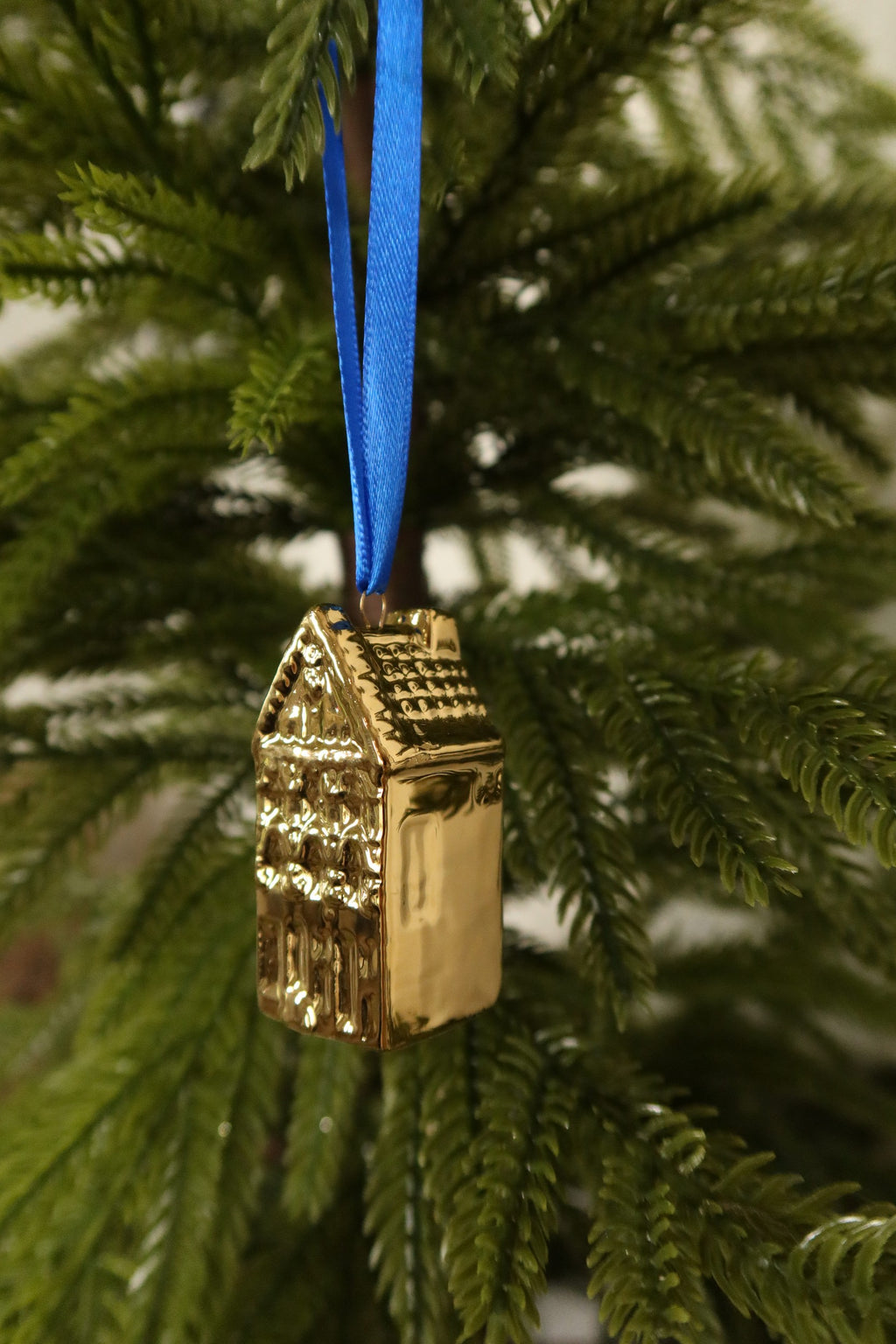 Side view of the pointed gable gold mini canal house ornament showing its tiled roof