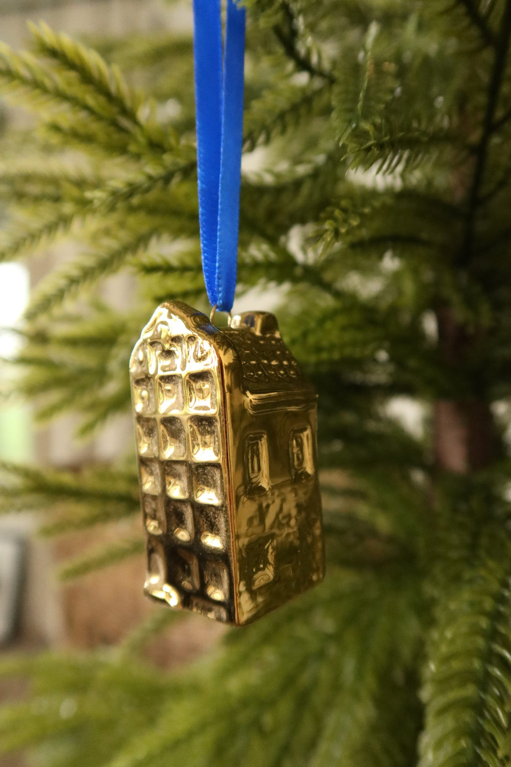 Side view of the rounded gable gold mini canal house ornament showing its textured roof