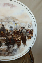 Close detail of the Christmas market scene on a Hammersley bone china plate, with a gentleman in a top hat, small Christmas trees and lit street lamps