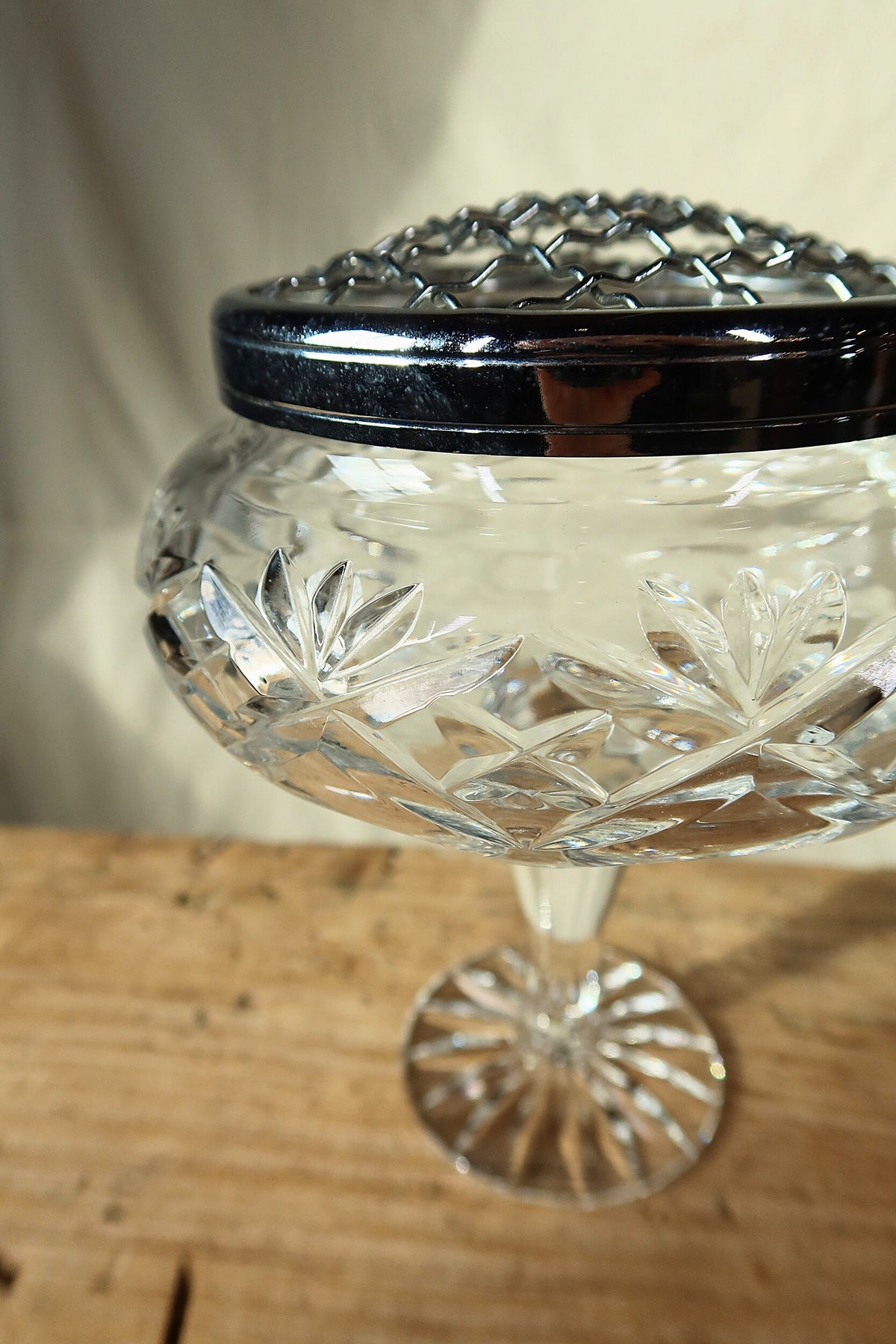 Close detail of the silver-tone wire grille and starburst cuts on the crystal flower frog bowl