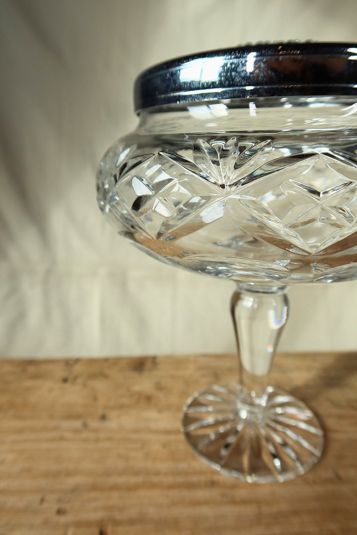 Side view of the crystal flower frog showing the diamond-cut bowl, clear stem and star-cut foot