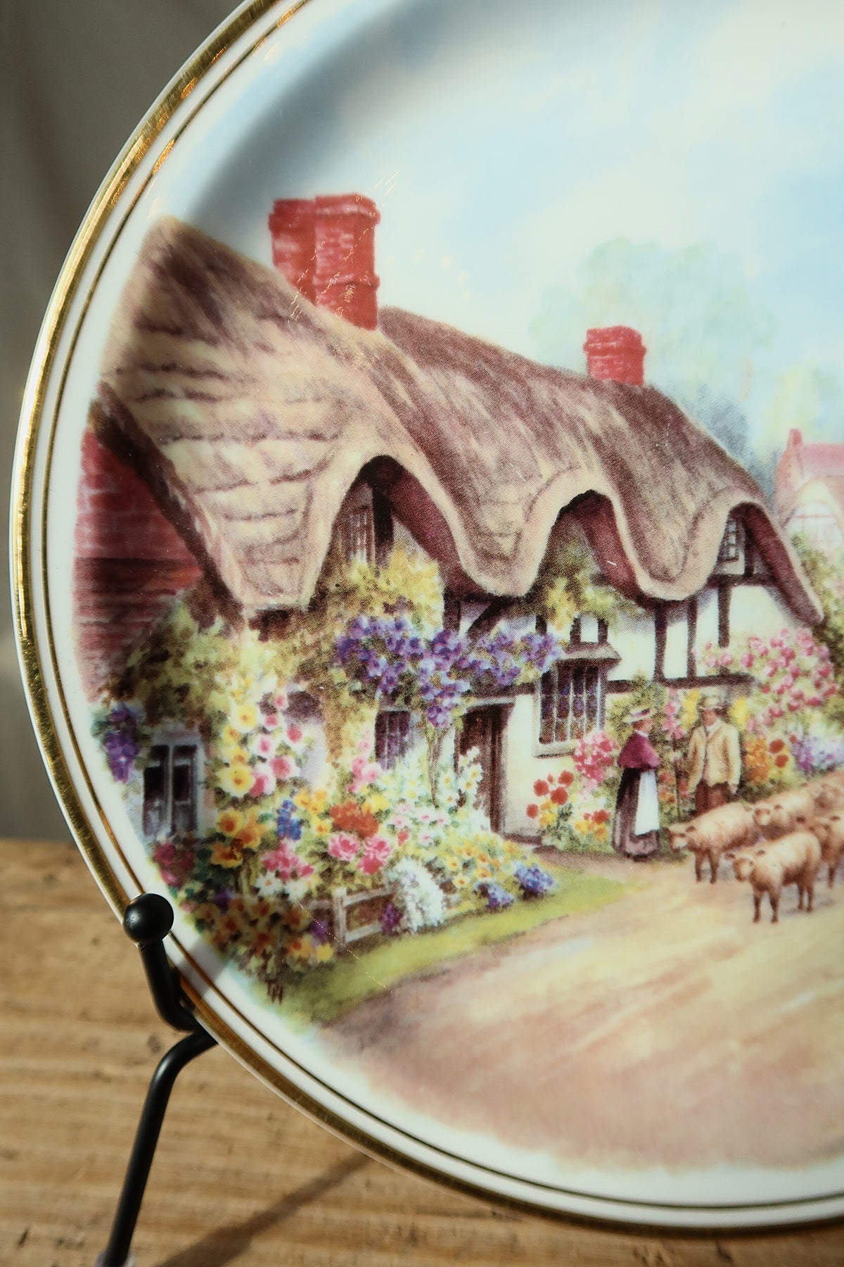Close detail of the thatched cottage, flower garden, couple and sheep on the Royal Vale English cottage plate