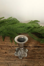 Top view of the 2.5 in silver cast iron taper candle holder showing the candle cup and leaf-patterned base