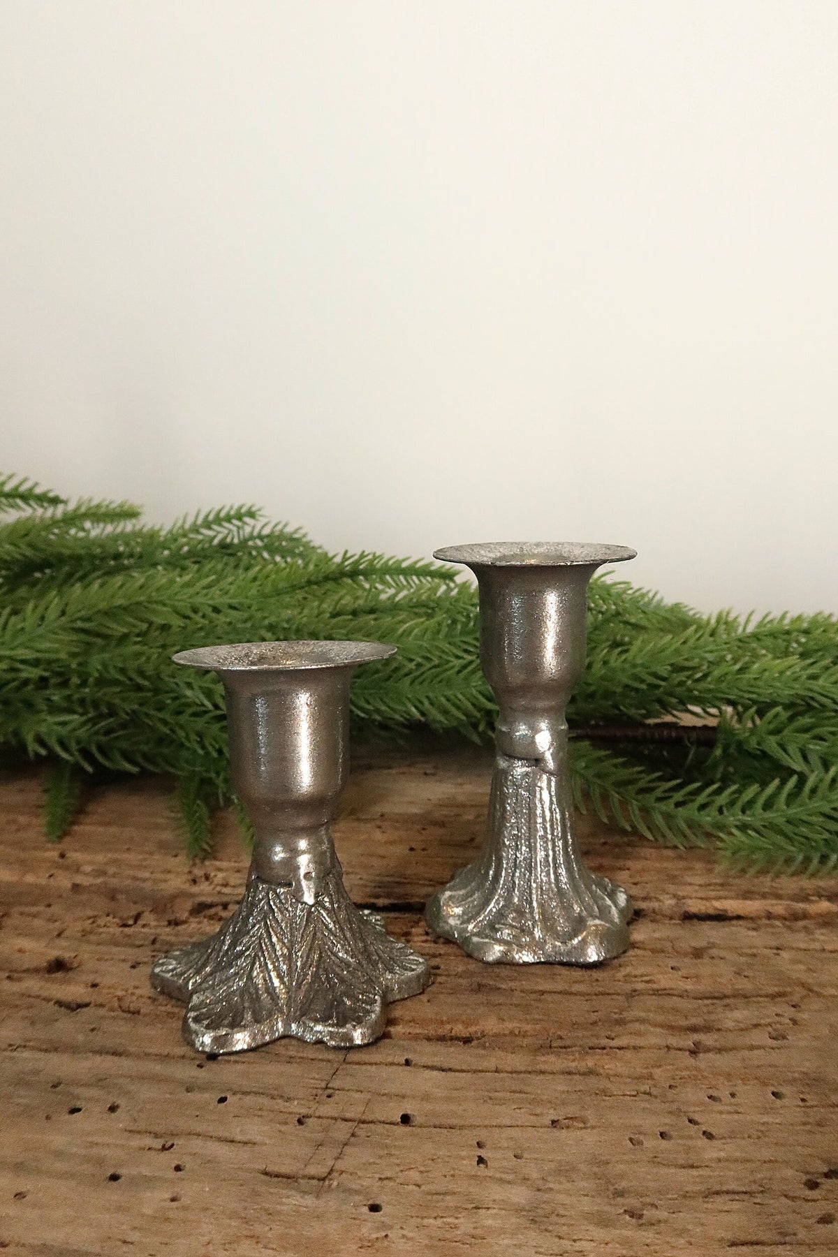 3 in silver cast iron taper candle holder shown beside the shorter 2.5 in leaf-base holder for size comparison