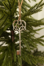 Closer view of the full silver metal key ornament hanging on a Christmas tree