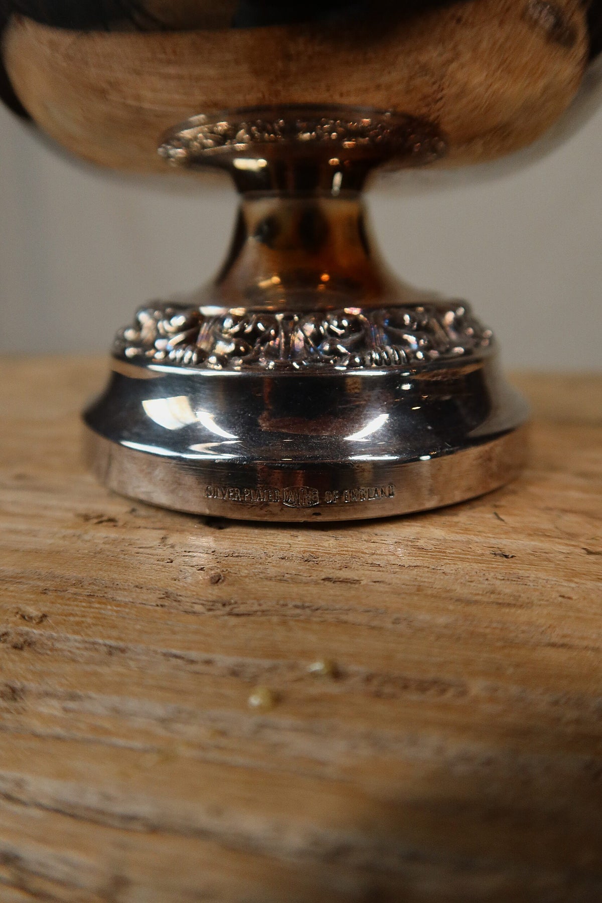 Close-up of the rose bowl's foot with the stamped Silver Plated Ianthe of England mark and warm tarnish to the silver